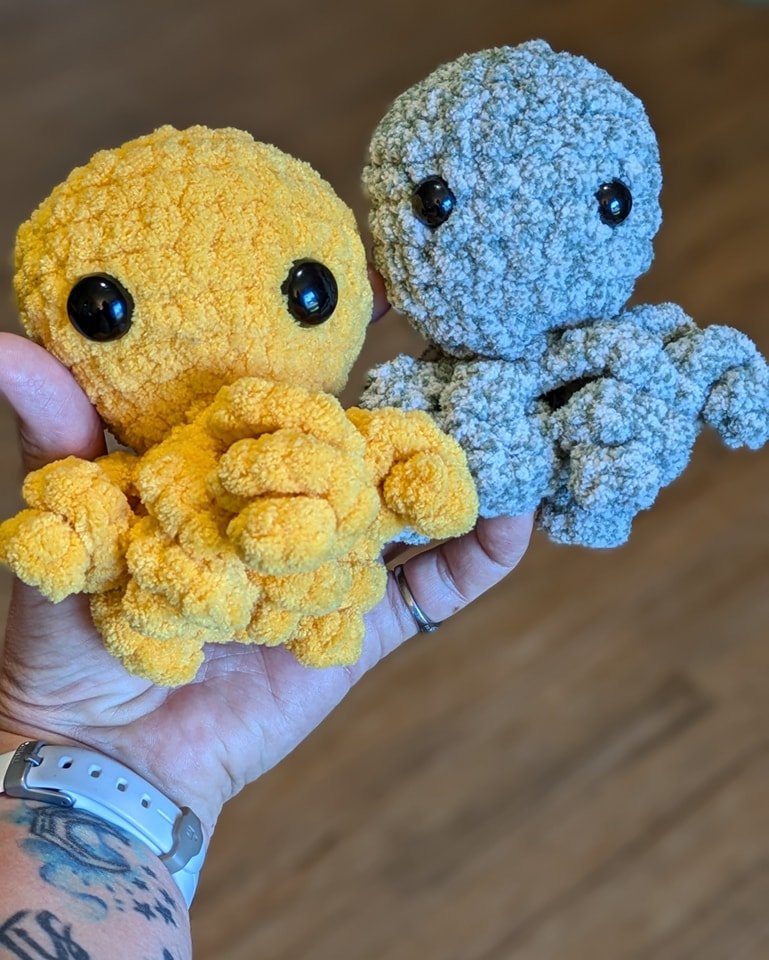 Two handmade yellow and blue crochet octopuses